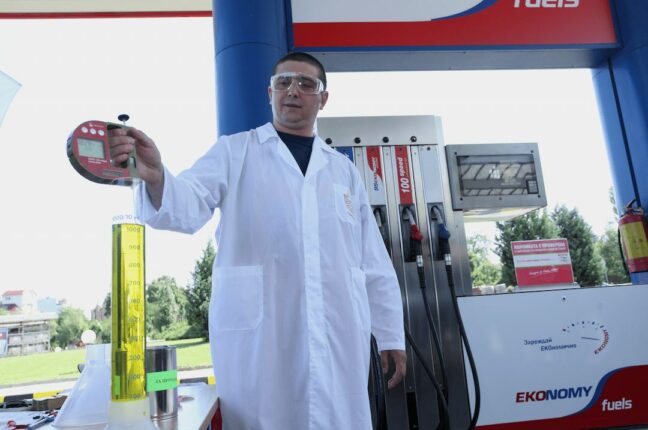 Inspector takes sample of gasoline to check the quality